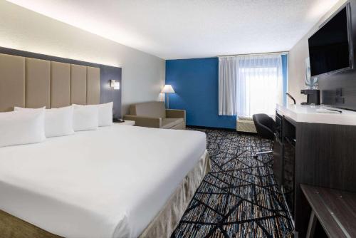 a large white bed in a hotel room at Baymont by Wyndham LaVergne in La Vergne