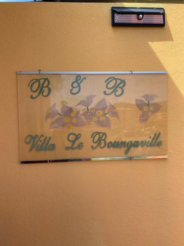 a sign on a wall with flowers on it at Villa le Bougainvillea in La Maddalena