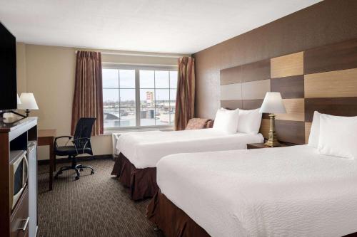 a hotel room with two beds and a window at AmericInn by Wyndham Cedar Rapids North in Cedar Rapids