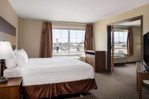 a hotel room with a bed and a large window at AmericInn by Wyndham Cedar Rapids North in Cedar Rapids