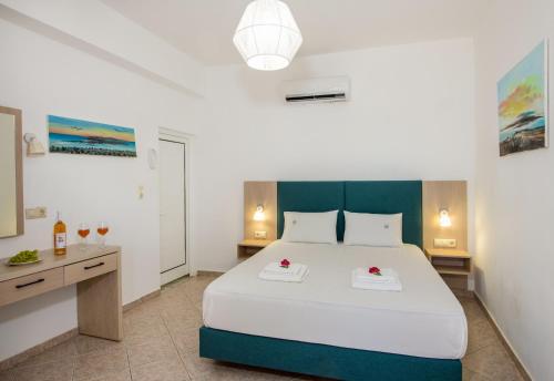 a bedroom with a large white bed and a desk at Elafonisi Village in Elafonisi