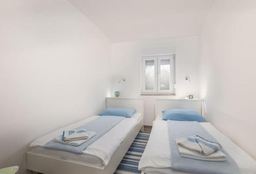 2 łóżka pojedyncze w pokoju z oknem w obiekcie Nice apartment with balcony very close to the sea w mieście Klimno