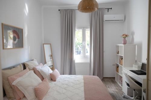 a bedroom with a bed with pink and white pillows at Irida’s detached house with lovely garden/yard in Athens city center in Athens