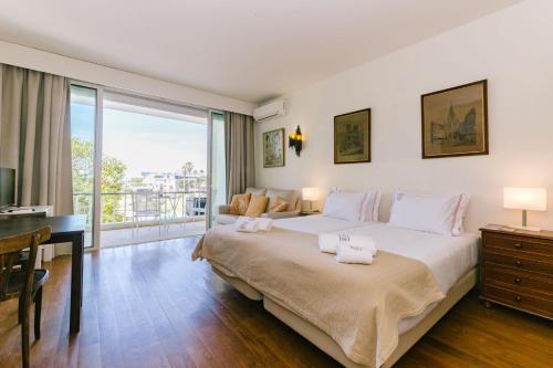 a bedroom with a large bed and a balcony at Rent4Rest Estoril Beachfront Apartments in Estoril