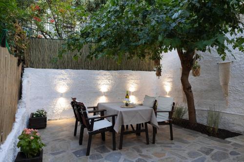 - une table et des chaises sur une terrasse avec un arbre dans l'établissement Irida’s detached house with lovely garden/yard in Athens city center, à Athènes