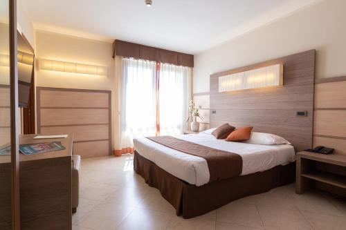 a bedroom with a large bed and a large window at NilHotel Florence in Florence