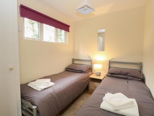two twin beds in a room with a mirror at 107 Kings Chalet Park in Cromer