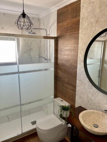 a bathroom with a toilet and a sink and a mirror at CHALET CON PISCINA PRIVADA in Torrevieja