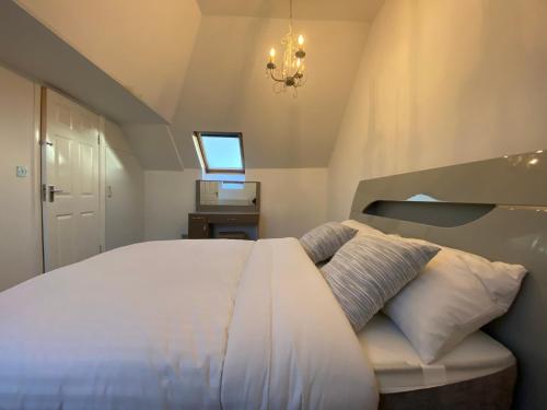 sypialnia z dużym białym łóżkiem i oknem w obiekcie Beautiful large 6 bedroom house up to 14 people w mieście Hendon