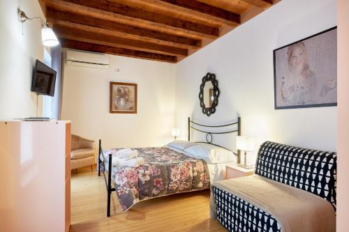 1 dormitorio pequeño con 1 cama y 1 sofá en Next to the library apartments, en Verona
