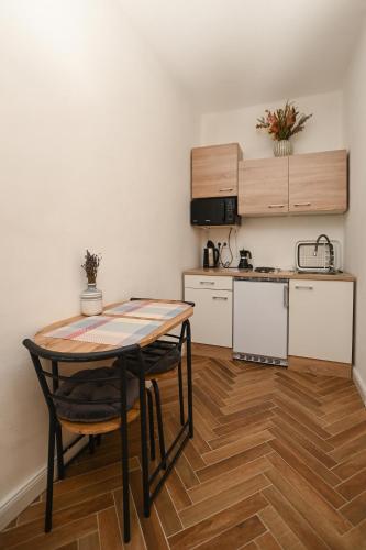 a small kitchen with a table and chairs in a room at Nana’s Vendégház in Mád