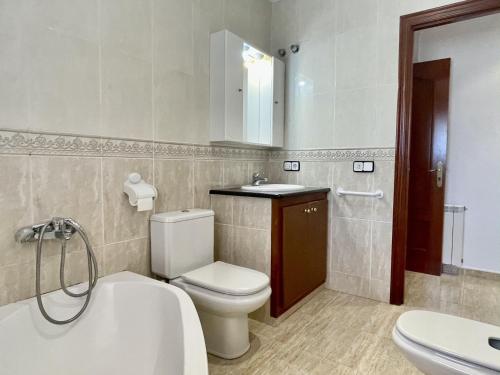 a bathroom with a toilet and a sink and a tub at Museu Baixos in L'Escala
