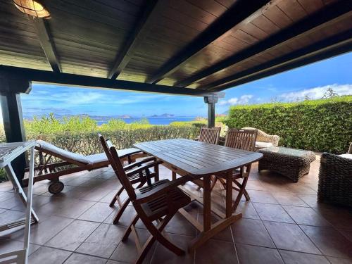 a wooden table and chairs on a patio at Residence Domos De Rocca in Monte Petrosu