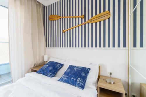 sypialnia z łóżkiem i dwoma kijami baseballowymi na ścianie w obiekcie Apartamenty Fenomen - Horizon, Nadmorskie Tarasy FREE PARKING, SWIMMING POOL, SAUNA AND OTHER! w Kołobrzegu