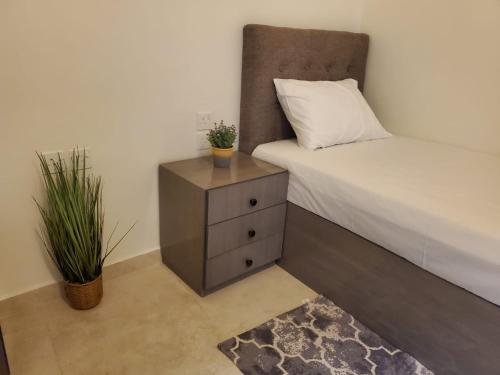 a bedroom with a bed and a nightstand with a pillow at شقة جمان طيبة Joman Taibah Apartment in Al Madinah