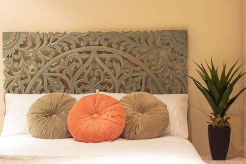 two orange pillows on a bed with a headboard at Dúplex Cuesta del Chapiz con vistas a la Alhambra by A3Rentals in Granada