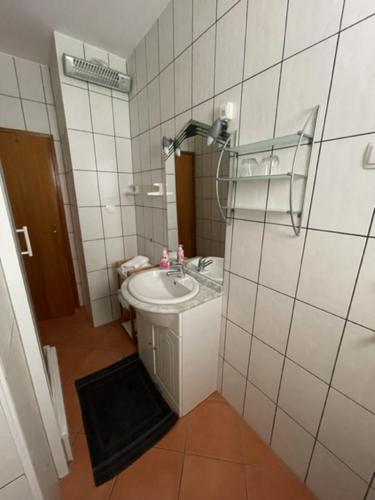 ein Bad mit einem Waschbecken und einem Spiegel in der Unterkunft Apartman Theresa in Barbat na Rabu