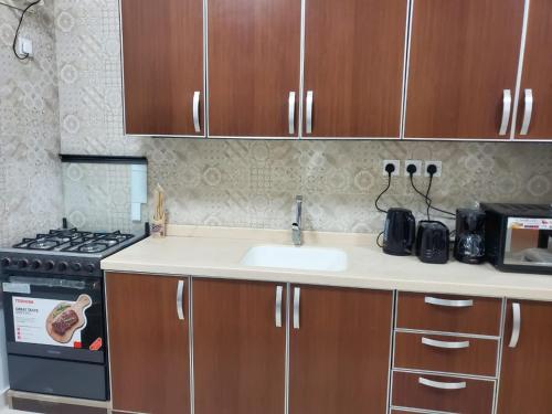 een keuken met een wastafel en een fornuis bij شقة جمان طيبة Joman Taibah Apartment in Al Madinah