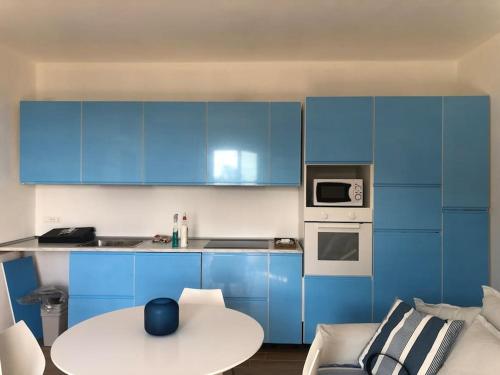 una cocina con armarios azules y una mesa blanca en Vista Portofino, en Zoagli