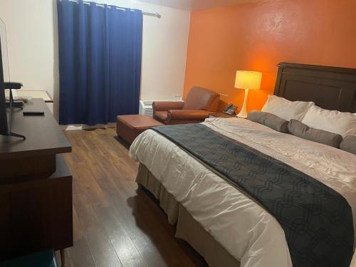 a hotel room with a bed and a chair at Alien Residence Inn in Pecos