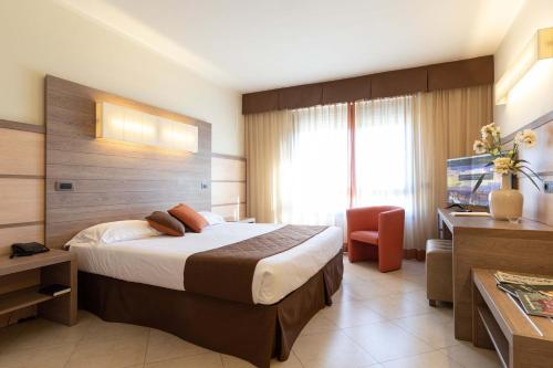 um quarto de hotel com uma cama e uma televisão em NilHotel Florence em Florença