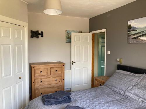1 dormitorio con cama y tocador de madera en Ballantrae en Wool