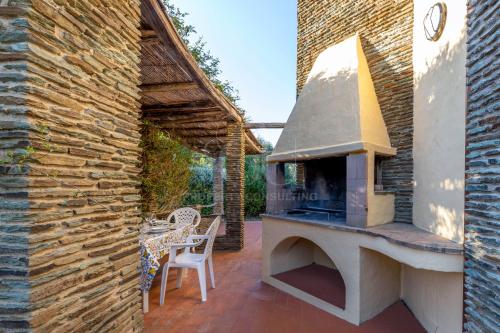 a patio with an outdoor oven on a brick wall at Il Glicine Cala Lupo in Stintino