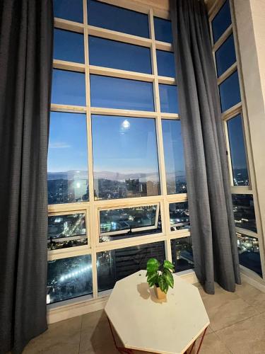 a room with a large window with a table and a plant at Home-like 2BR Unit in the Center in Cebu City
