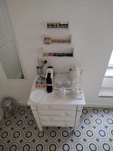 a white table with cups and plates on it at BellaVita accomodation in Tropea