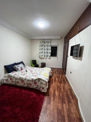 1 dormitorio con cama y alfombra roja en Résidence Faouazi en Casablanca
