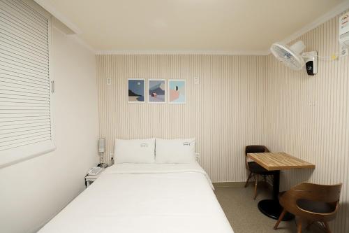 Habitación pequeña con cama y mesa en Stay RomanticTrip_Hostel en Gyeongju