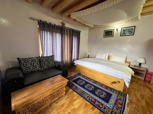 a bedroom with a bed and a couch in it at Raku Guest house in Leh