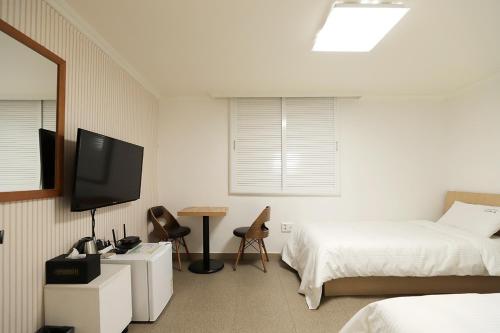 a bedroom with a bed and a tv and a desk at Stay RomanticTrip_Hostel in Gyeongju