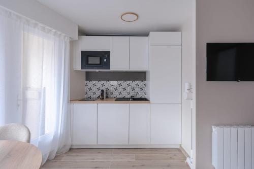 - une cuisine blanche avec des placards blancs et un four micro-ondes dans l'établissement Luxurious 4P1BR apartment renovated with taste - Deauville, à Deauville