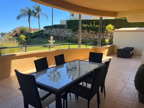 a glass table and chairs on a patio at New refurnished Apartment Elviria Hills Marbella in Marbella