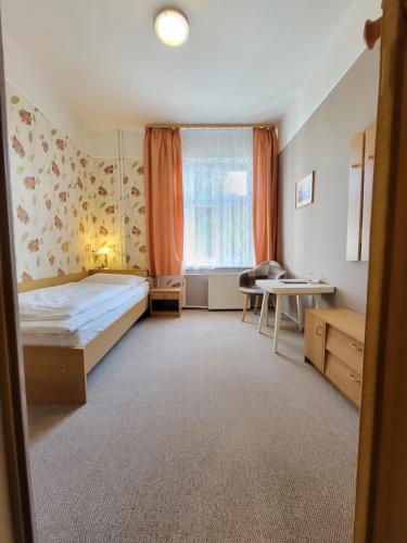 niewielka sypialnia z łóżkiem i stołem w obiekcie Penzion Ostravanka w mieście Hranice