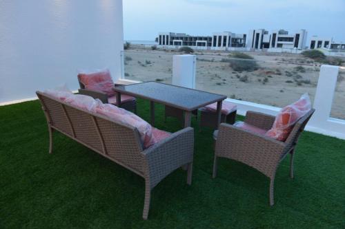 a table and two chairs with pillows on a patio at استراحة المرجانalmarjan chalet in Ḑibāb