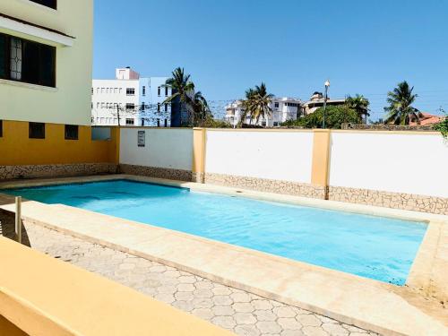 a swimming pool on the side of a building at Lux Suites Furaha Holiday Apartments Nyali in Mombasa