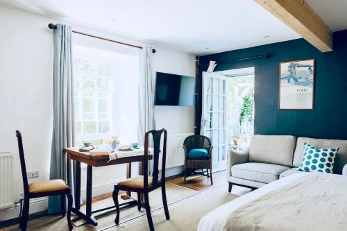1 dormitorio con cama, escritorio y silla en The Garden Room Apartment en Cardigan