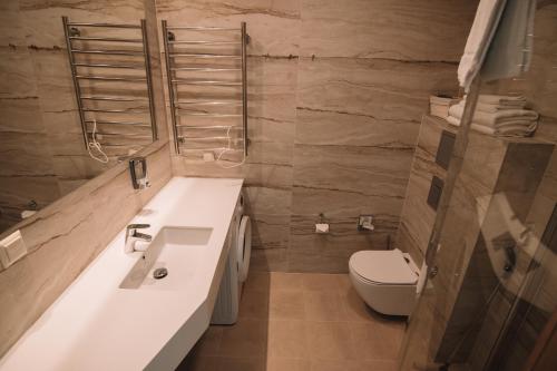 La salle de bains est pourvue d'un lavabo et de toilettes. dans l'établissement Merepargi ApartHotel & Cafe, à Narva-Jõesuu