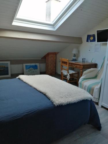 une chambre avec un lit et une lucarne dans l'établissement Maison d'hôtes le clos de la Presle, Compostelle, à Saint-Georges-Haute-Ville