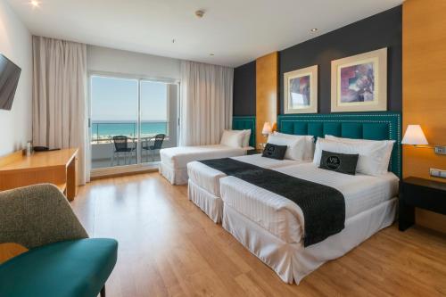 a hotel room with two beds and a balcony at VS Gandía Palace Hotel **** in Gandía