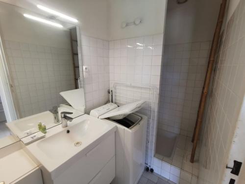 une salle de bain blanche avec un lavabo et une douche dans l'établissement 5026 Tennis Village 111, au Cap d'Agde
