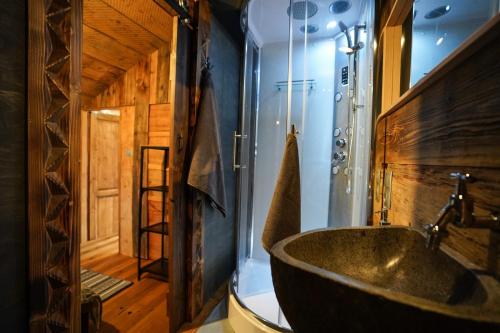 a bathroom with a large tub and a wooden wall at Górna Chata Mountains Chalet in Ochotnica Górna