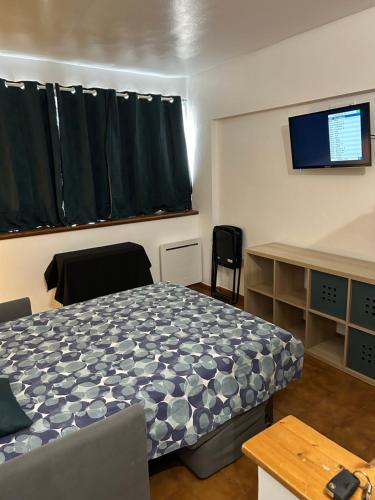 Cette chambre comprend un lit, un bureau et une télévision. dans l'établissement STUDIO CASSIS, à Cassis