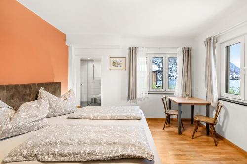 a bedroom with two beds and a desk and windows at Hallstatt Lakeside Top 1 in Hallstatt