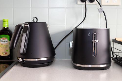 two black appliances sitting on a kitchen counter at The Forest Nest - private garden studio in Forestville