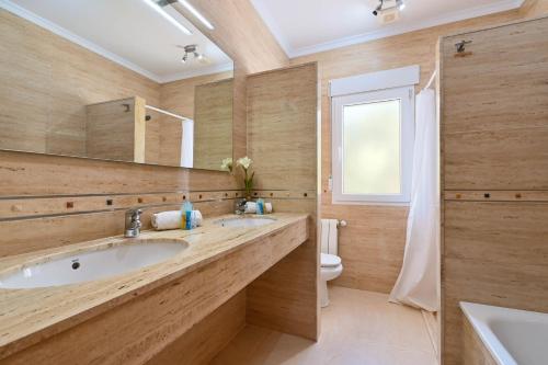 a bathroom with two sinks and a toilet at Frederique in Benitachell