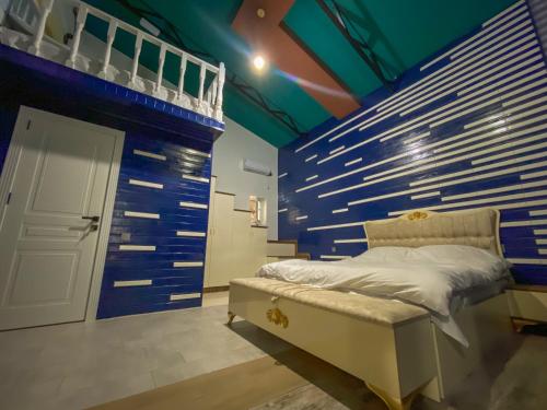 um quarto com uma cama e uma parede azul em Miramida Hotel em Zaqatala