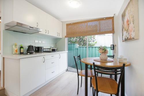 a kitchen with a table and chairs in a room at The Forest Nest - private garden studio in Forestville